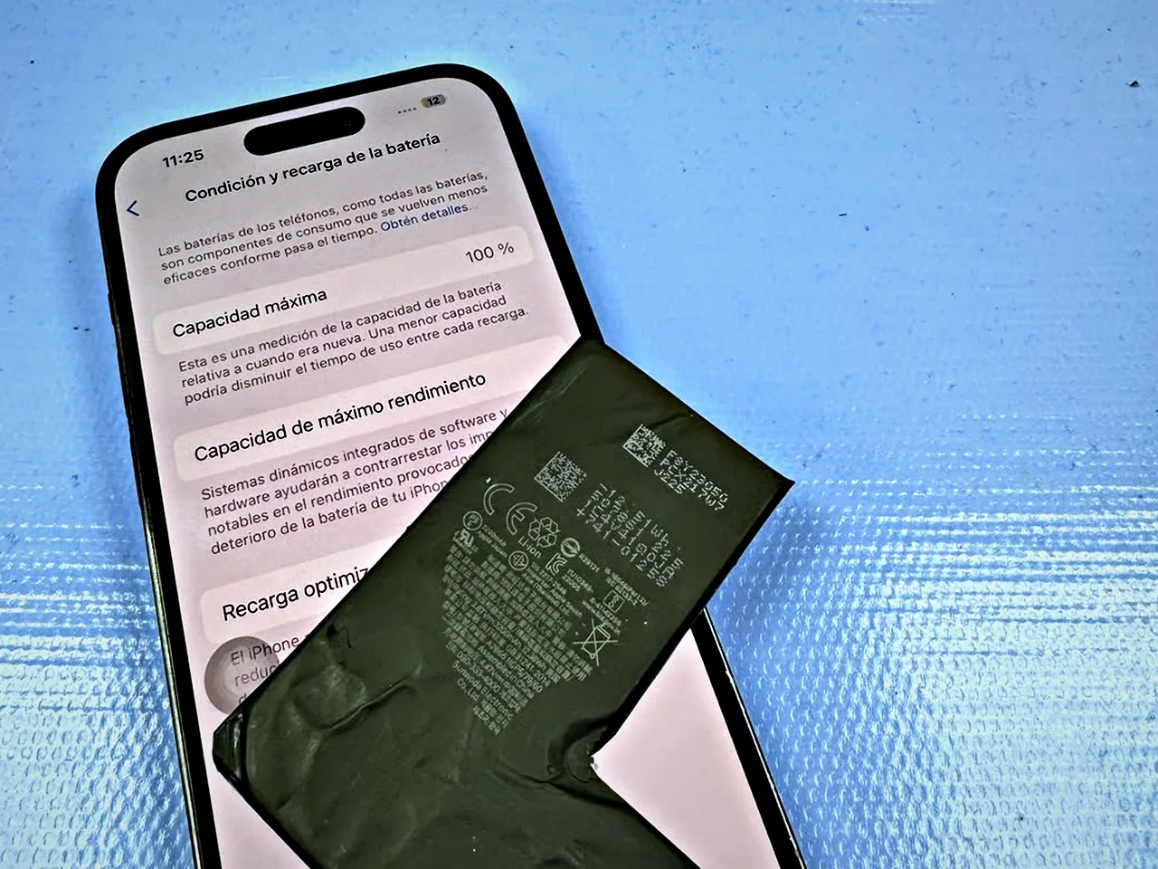 iPhone mostrando la condición de la batería al 100% junto a una batería de repuesto
